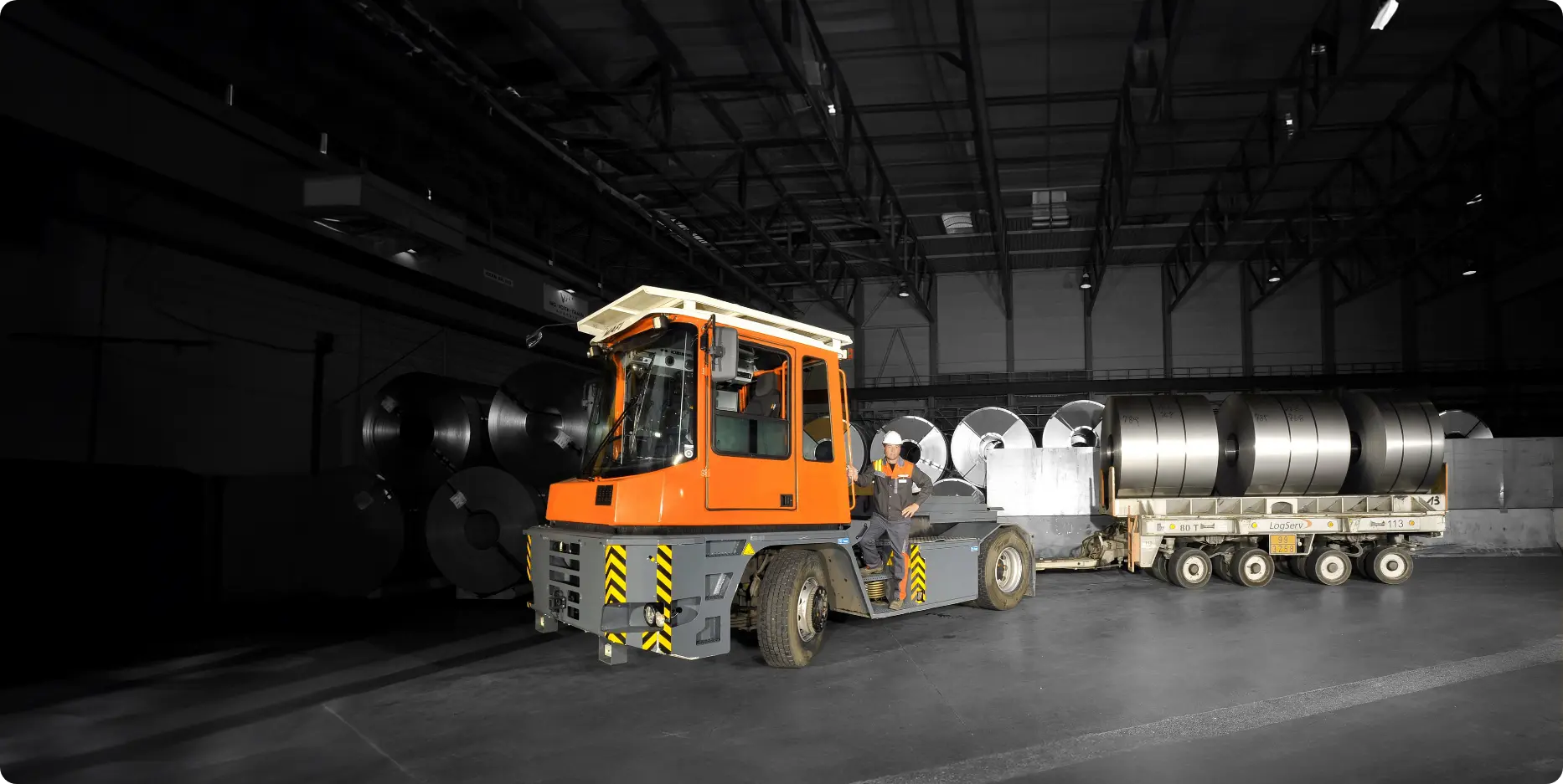 Innenaufnahme mit Stahltransport in dunkler Halle