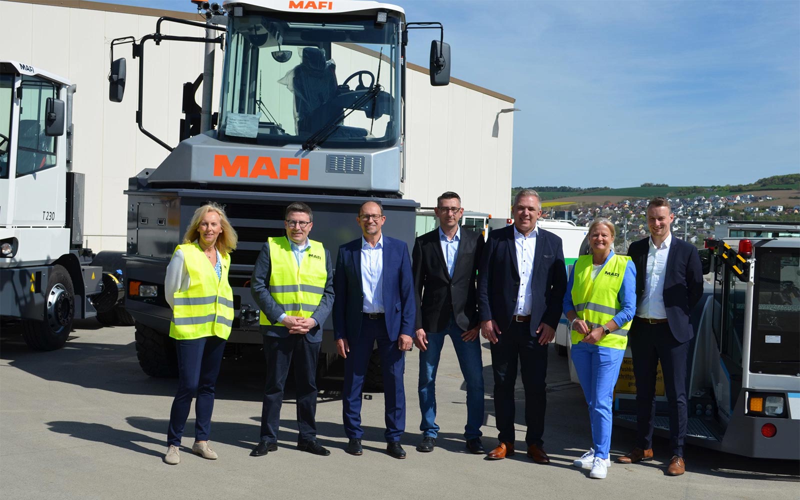 Gruppenfoto vor Industriefahrzeugen